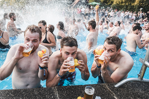 Festivalbesucher im Pool mit Enten